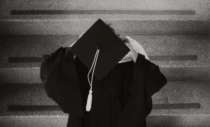 Graduate standing on stone steps